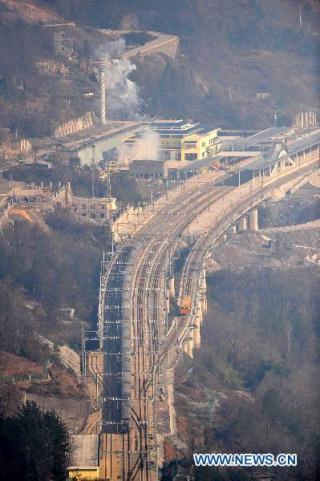 A train runs past the Badong station along the Yichang-Wanzhou railway in central China's Hubei Province, Dec. 22, 2010. The Yichang-Wanzhou railway, linking Yichang in central China's Hubei Province and Wanzhou in southwest China's Chongqing Municipality, started operation Wednesday. The 377-kilometer-long railway, considered to be China's most difficult and expensive to build, snakes through 159 tunnels and 253 bridges in southwestern China's mountainous regions.. (Xinhua/Hao Tongqian)