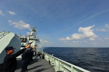 Chinese navy soldiers fire flares to celebrate the first anniversary of the Chinese fleet's escort mission on Ma'anshan frigate of the fourth Chinese naval flotilla in the Gulf of Aden, Dec. 26, 2009.(Xinhua/Yang Zhigang)