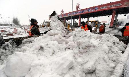 Workers clear snow at Harbin-Tongjiang Road near Harbin, capital of northeast China's Heilongjiang Province, Feb. 24, 2010. Most regions in Heilongjiang witnessed heavy snow since late Feb. 23 and three of five expressways in the province have been closed. (Xinhua/Li Yong)