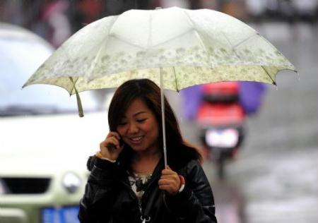 A woman holds an umbrella as she walks in the rain in Kunming, capital of southwest China's Yunnan Province, March 28, 2010. The rainfall brought some relief to parched Yunnan Province on Sunday as a severe drought ravages southwest China.(Xinhua/Lin Yiguang)