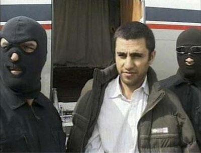 This frame grab released February 23, 2010 from Iranian state TV shows Sunni Muslim rebel leader Abdolmalek Rigi under armed guard following his arrest.