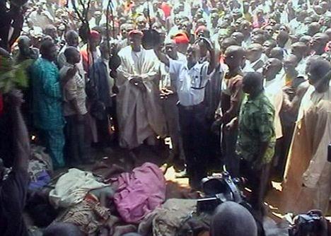 A crowd gathers as bodies of the victims of the massacre are laid out in the town of Dogo Nahawa, Nigeria