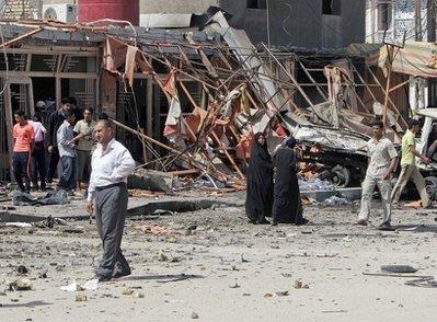 Iraqis inspect the scene of a bomb attack in central Karbala, 80 kilometers (50 miles) south of Baghdad, Iraq, Monday, March 29, 2010. A pair of car bombs went off in the holy city of Karbala.(AP Photo/Ahmed al-Husseini) 