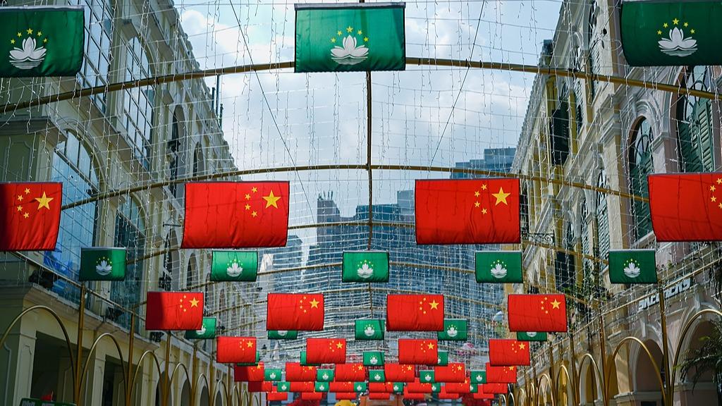 Macao celebrates 25th anniversary of return to China with five-star red flags displayed cross streets