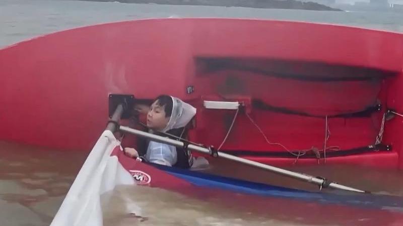 Coach takes tough-love approach as 10-year-old's sailboat capsizes in rain