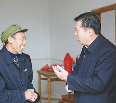 刘洪（右）在下七乡下七村走访贫困户。（资料照片））
