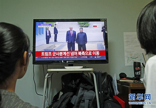 6月30日，韩国首尔市民在家里收看朝鲜最高领导人金正恩（屏幕右侧）与美国总统特朗普会面的电视直播。 据韩国媒体报道，美国总统特朗普30日在板门店与朝鲜最高领导人金正恩会面，这是两人继新加坡会晤和河内会晤后的第三次会面。 新华社记者王婧嫱摄