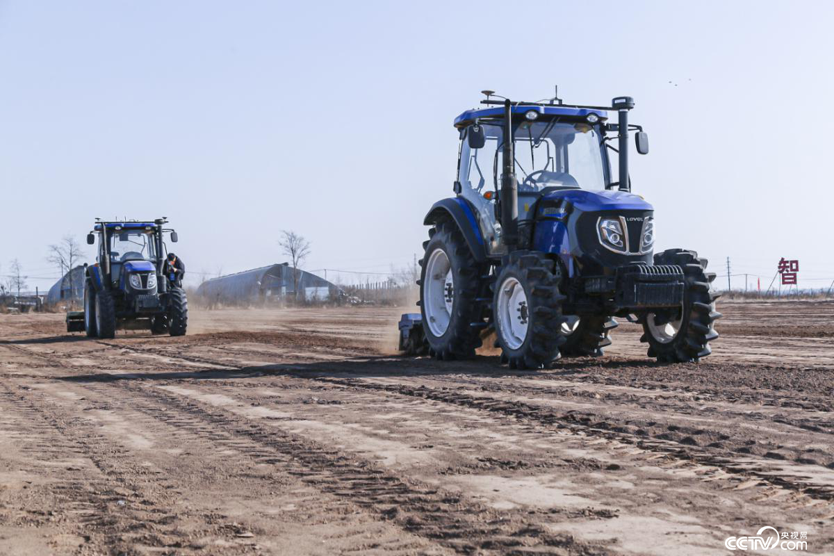 无人驾驶拖拉机牵引旋耕机对地块进行耕整作业