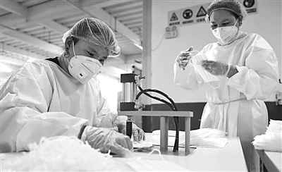 防护物资生产企业全力保障供应。新华社发