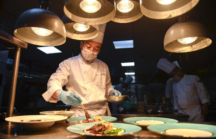 在长春市一家酒店内，厨师将原本用大盘盛装的菜品改为单人份。新华社记者 许畅 摄