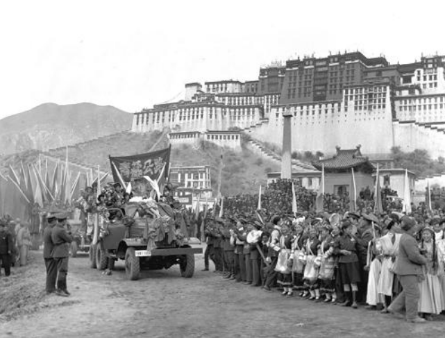△从青藏公路开到拉萨布达拉宫前的汽车队，受到当地人民的夹道欢迎