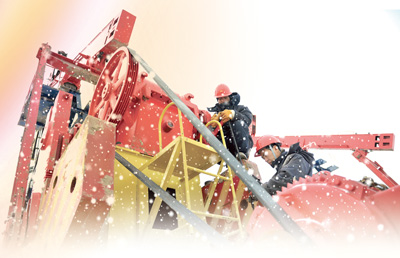 石油工人们在风雪中安装抽油机。