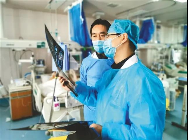 △援藏专家和日喀则市人民医院神经外科医生探讨病人术后康复情况。