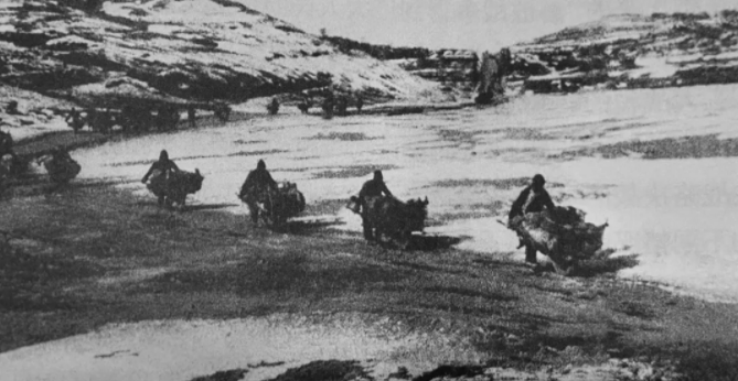 三大战役期间，解放区农民在冰天雪地中用小车把弹药、物资运往前线。图片来源：《中国共产党的九十年》