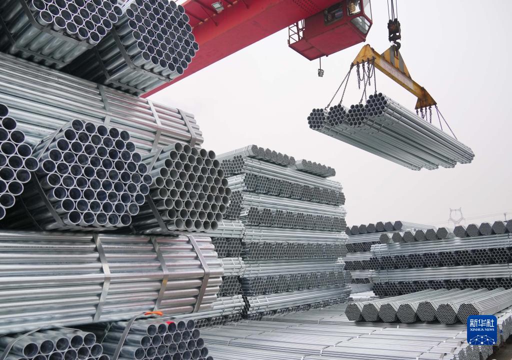河北省遷安市一家鍍鋅管生產企業的工人操作機械設備吊運鋼管（2021年12月11日攝）。新華社記者 楊世堯 攝