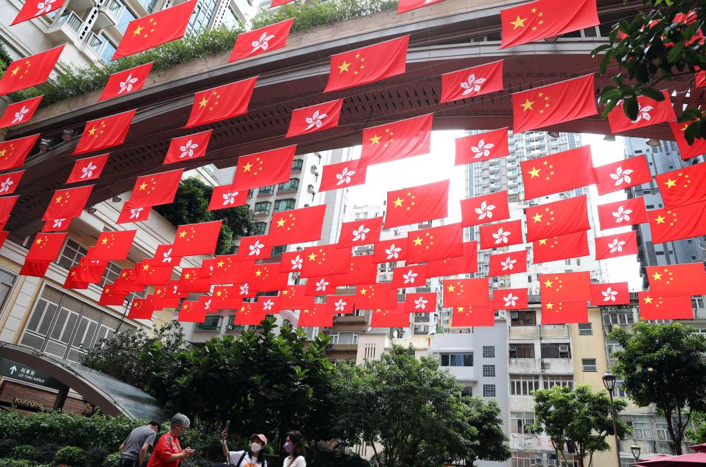 6月16日，在香港利东街，中华人民共和国国旗和香港特别行政区区旗迎风飘扬。新华社记者 李钢 摄