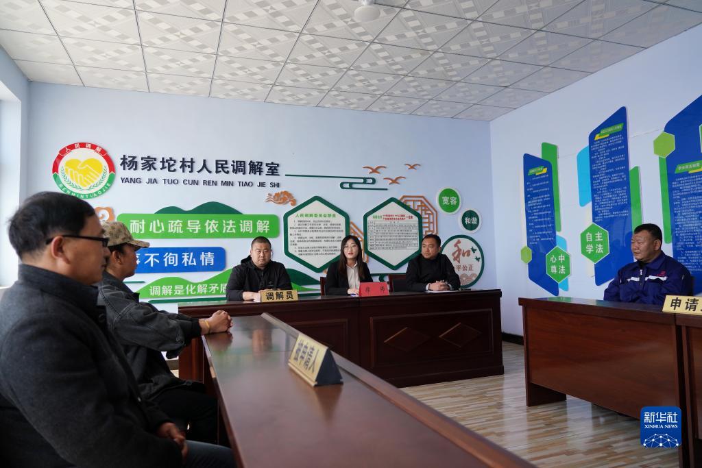 律师甄彩丽（中）在河北唐山滦州市茨榆坨镇杨家坨村人民调解室内为群众解答法律问题（2021年4月18日摄）。