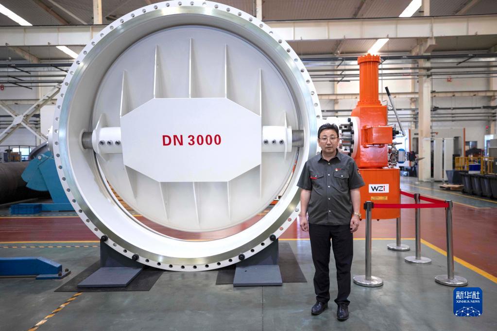 　　马玉山在位于宁夏吴忠市的吴忠仪表有限责任公司自动化产业园数字化装配车间中，左侧为该公司生产的DN3000三偏心蝶阀（9月12日摄）。 
