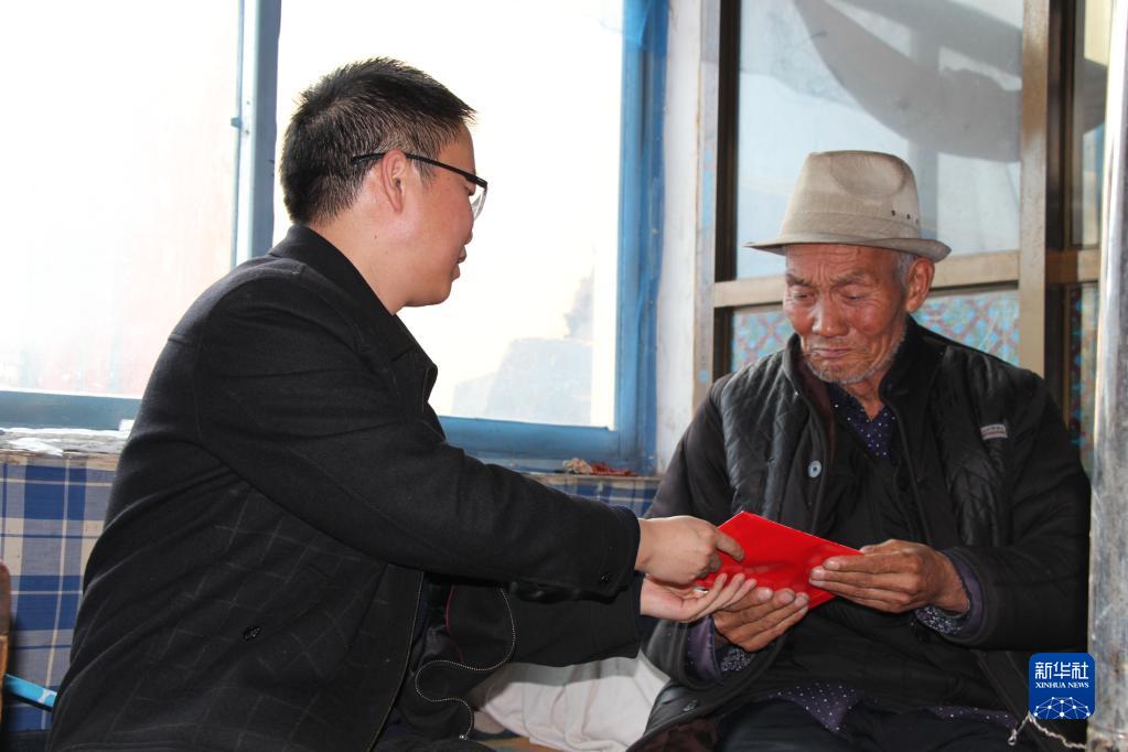 朱治国（左）在青海省黄南藏族自治州慰问生活困难党员（2019年1月摄）。