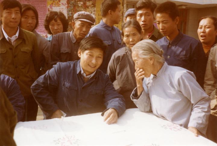 1983年，时任河北正定县委书记的习近平（前排居中），临时在大街上摆桌子听取老百姓意见。