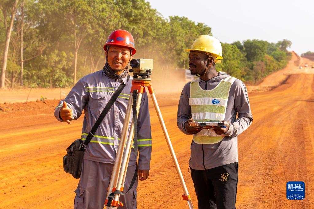 On April 13th, in Odienne province, northwest of Cô te d 'Ivoire, surveyor Kama (right) from Togo and his master Li Jian from China worked at the construction site of the northern highway project. Xinhua News Agency reporter Zheng Yangzi photo
