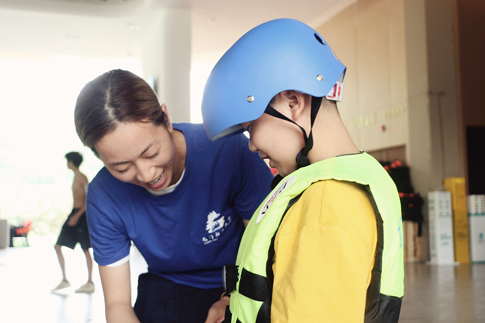 云溪谷漂流项目工作人员指导儿童穿戴安全护具。（何川 摄）