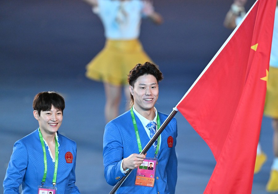Flagbearers of the delegation of China Yang Liwei (L) and Qin Haiyang parade into the Hangzhou Olympic Sports Center Stadium. (Xinhua/Zhan Yan)