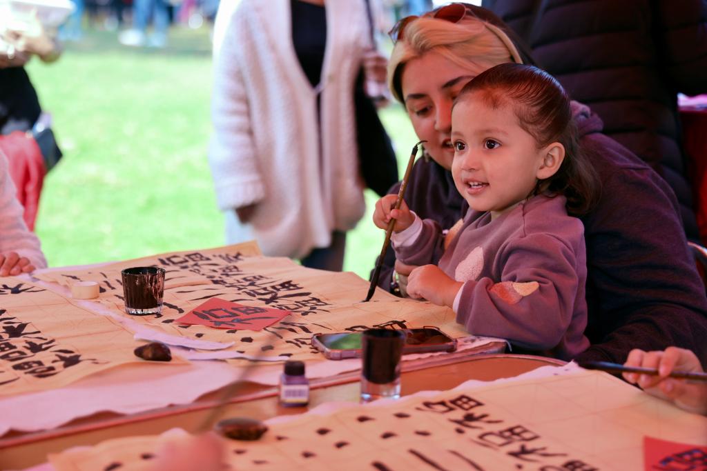 A girl learns Chinese calligraphy at the 4th edition of the Chinese New Year cultural festival at the National Arts Center in Mexico City, capital of Mexico, Jan. 25, 2025. (Xinhua/Li Mengxin)