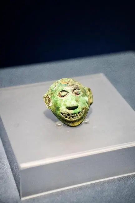 西汉前期至西汉中期·人面型铜扣饰，赫章可乐遗址373号墓出土，贵州省博物馆藏