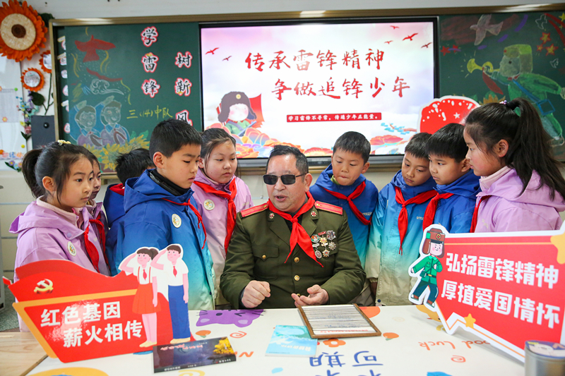 2025年3月3日，江苏南通如皋市安定小学里，伤残军人许波银在思政小课堂上向学生讲述雷锋故事。