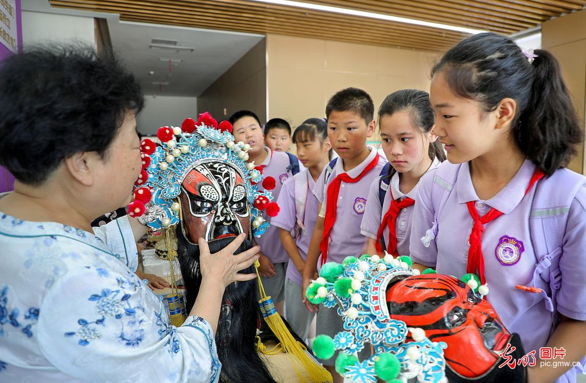 在秦都区文华学校,陕西省咸阳市秦都区文化和旅游局、秦都区教育局举办非遗宣传活动。20多个非遗项目的展示,让师生领略到了非物质文化遗产的韵味与魅力。图为非遗传承人向学生展示非遗项目秦腔脸谱绘制技艺。(李军朝摄/光明图片)