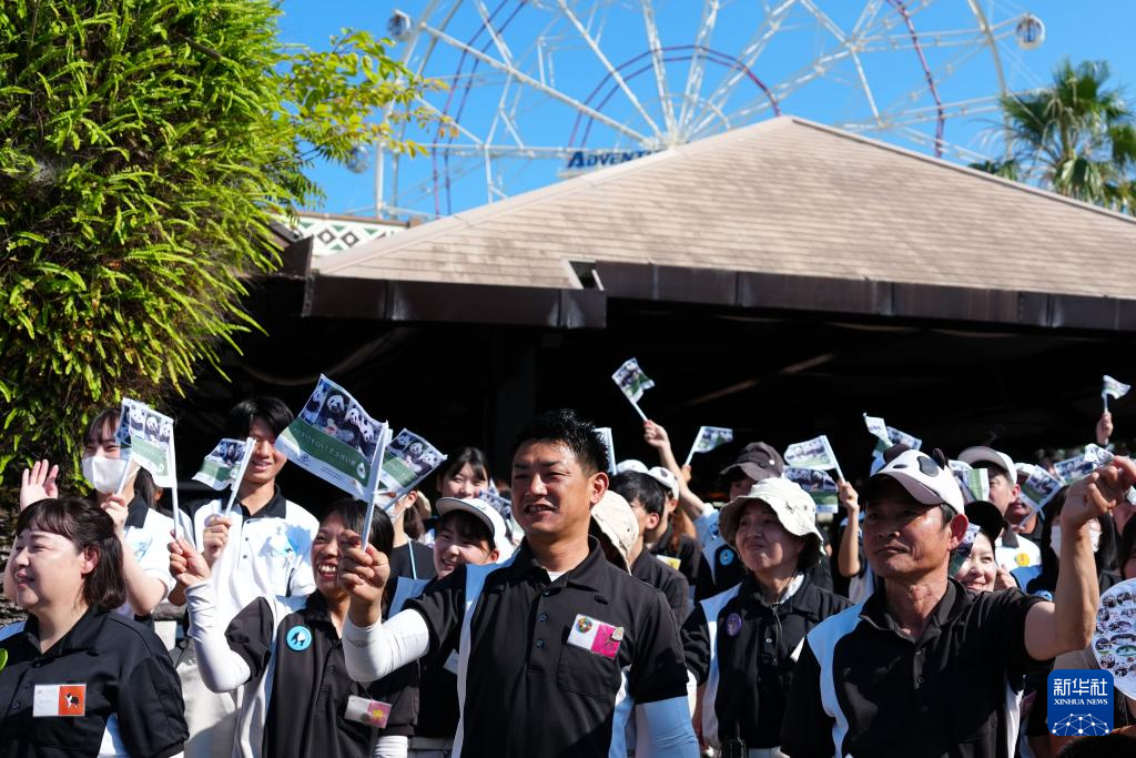 6月28日，工作人员与当地民众在日本和歌山县冒险世界游乐园外目送运输大熊猫的卡车离开。新华社记者 贾浩成 摄
