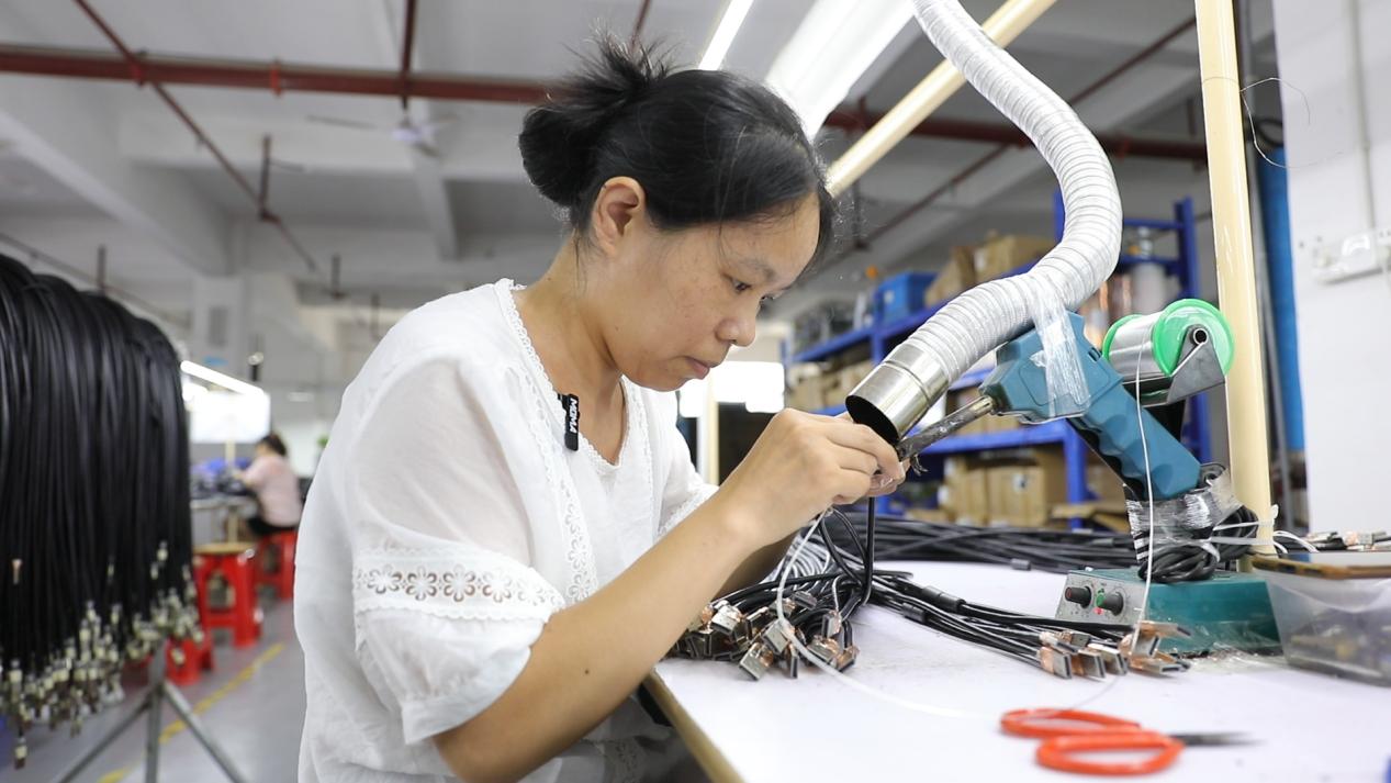 移民易拾连正在进行数据线作业（黄春华/摄）