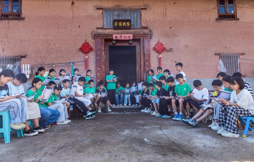 孩子们在瑶寨传统民居前学习国学（刘国忠/摄）