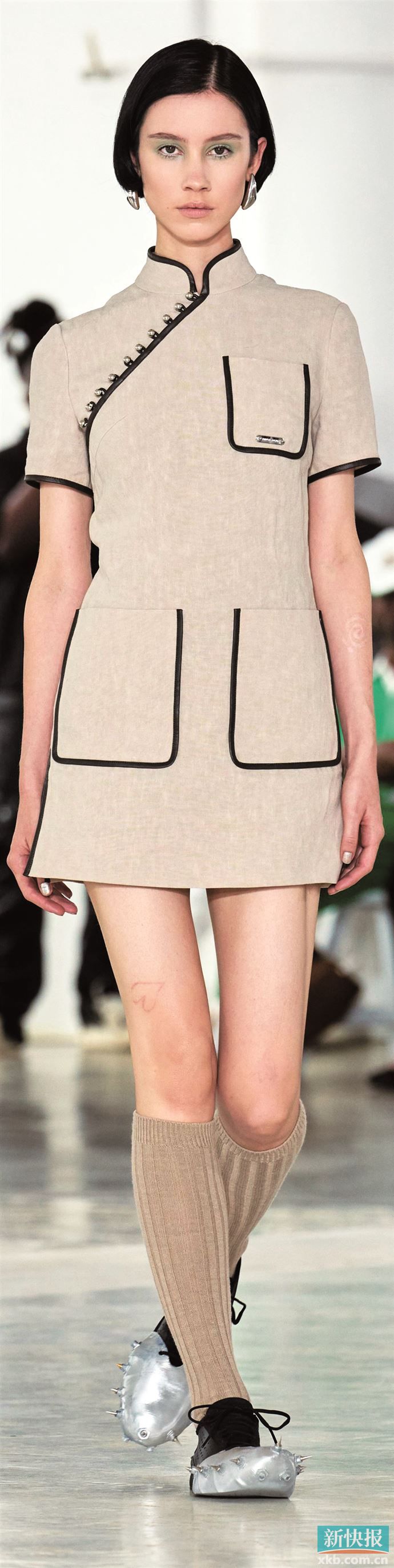 皮革缝边为改良后的立领提供新支撑力，细节中展现东西方时装文化融合的新趋势。