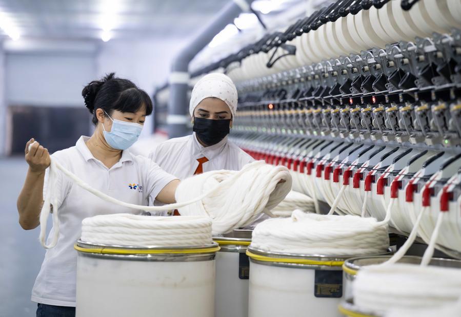 A Chinese workshop manager (L) instructs a Tajik worker at China-Tajikistan Danghara Agricultural and Textile Industrial Park in Danghara, Tajikistan, on Sept. 12, 2025. (Xinhua/Li Renzi)