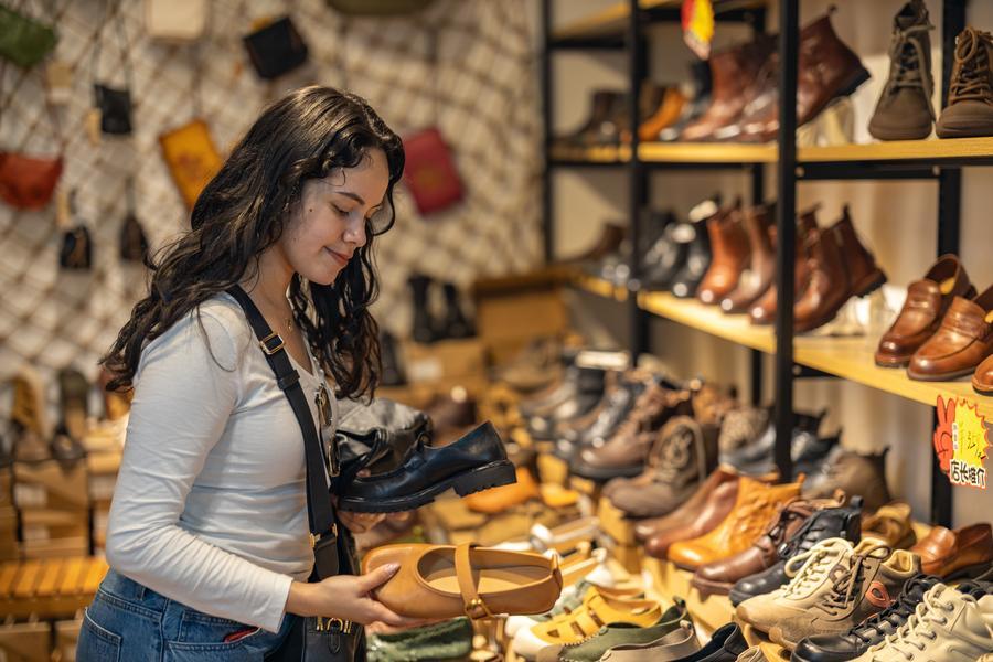 A tourist from Mexico purchases shoes at an international smallware wholesale market in Yuzhong District of Chongqing, southwest China, April 22, 2026. (Xinhua/Huang Wei)