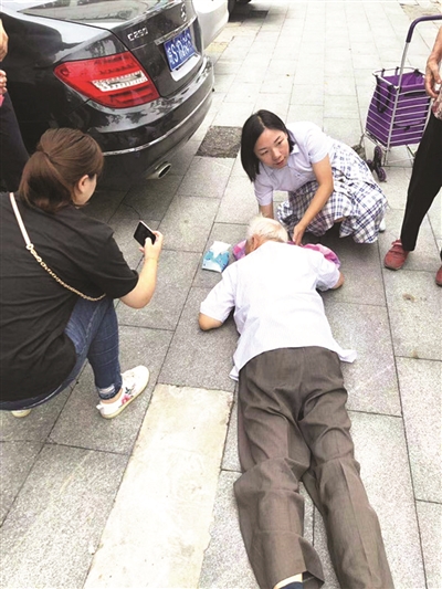 八旬老人摔倒流血 女子蹲地"托举"20分钟