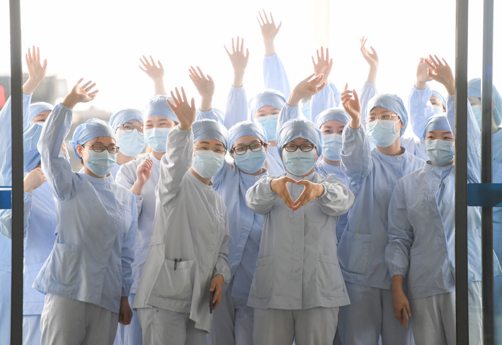 2020年3月23日，在武汉天河机场，湖北省武汉市第一医院医护人员为广东第14批援鄂医疗队送行。